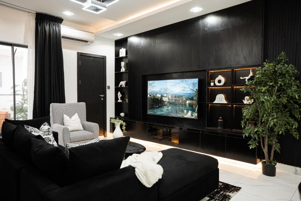 a living room with a black wall and a tv at Brand New 2bed flat close to the beach with 2 balconies in Lekki