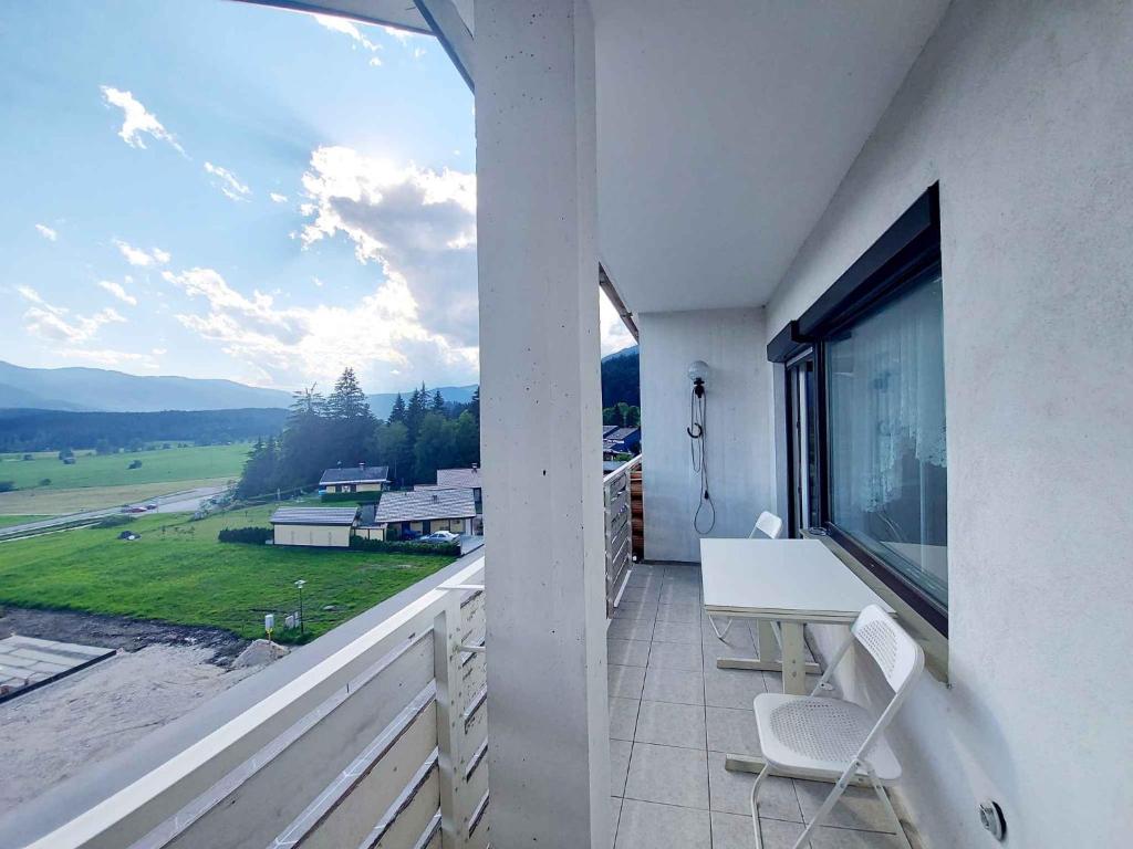 un balcon avec un bureau et une grande fenêtre dans l'établissement Apartments in Bad Mitterndorf - Steiermark 41117, à Bad Mitterndorf