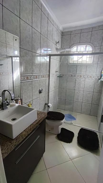 a bathroom with a sink and a toilet at Cama Quarto Compartilhado Hostel Pousada Tijucas Lua Encantada in Tijucas