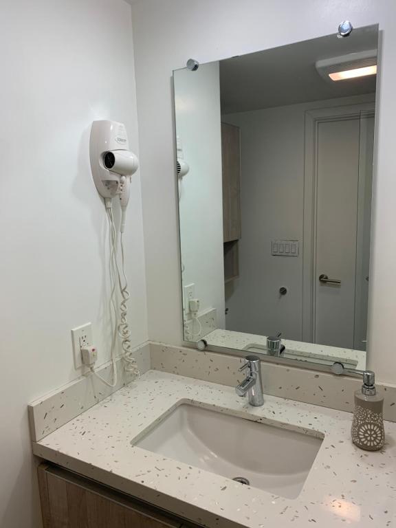 Un baño con lavabo y un espejo grande. en Western Romaine, en Los Ángeles