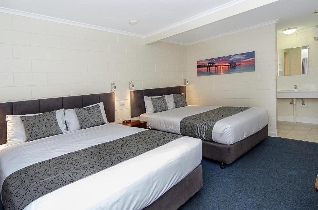 a hotel room with two beds and a bathroom at Victor Harbor City Inn in Victor Harbor