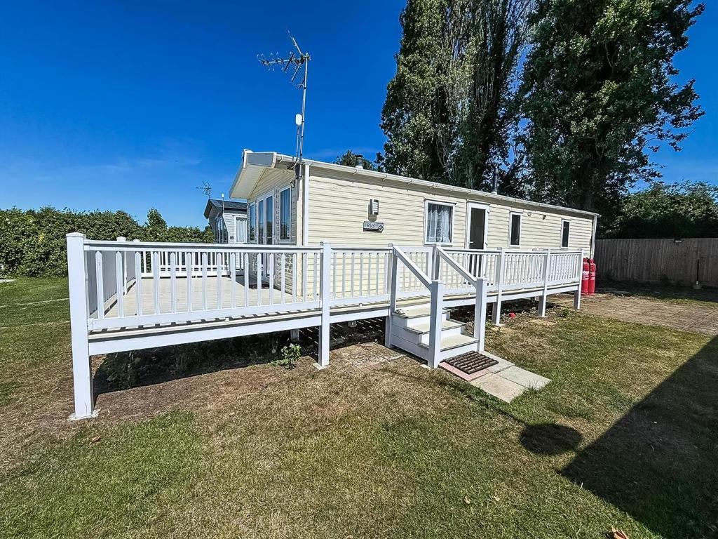 a white mobile home with a white fence at Gorgeous 6 Berth Caravan With Decking Area, Dovercourt Holiday Park Ref 44510A in Great Oakley