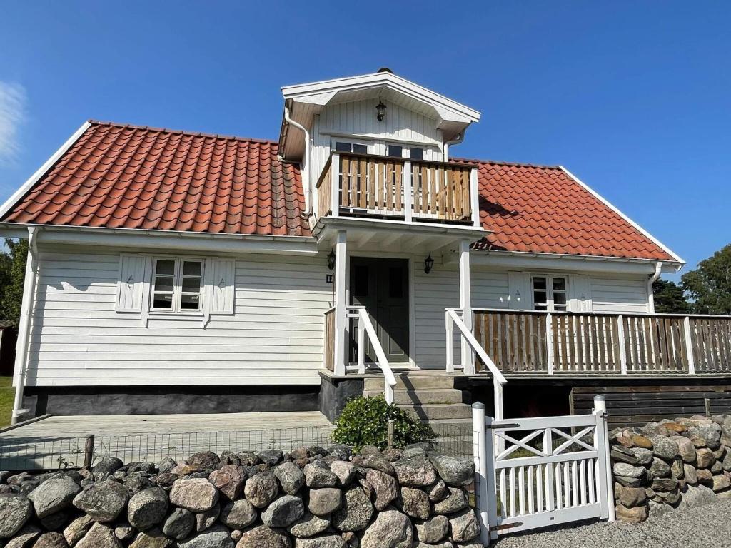 a white house with a deck and a balcony at 4 star holiday home in SÖLVESBORG in Sölvesborg