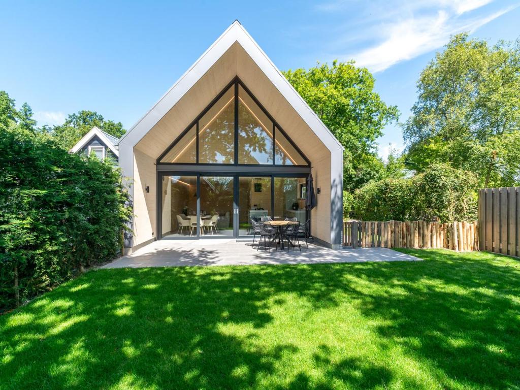 a house with a large window on a lawn at Luxury holiday home by the sea in Sint Maartenszee