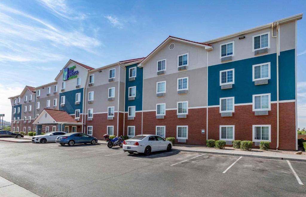 Un gran edificio con coches aparcados en un estacionamiento. en Extended Stay America Select Suites - Phoenix - North, en John C Lincoln Helistop