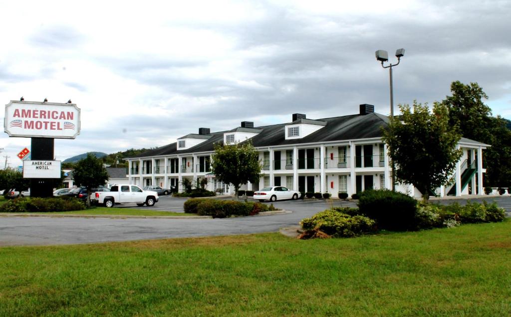 un cartel de motel americano frente a un edificio en American Motel - Lenoir, en Lenoir