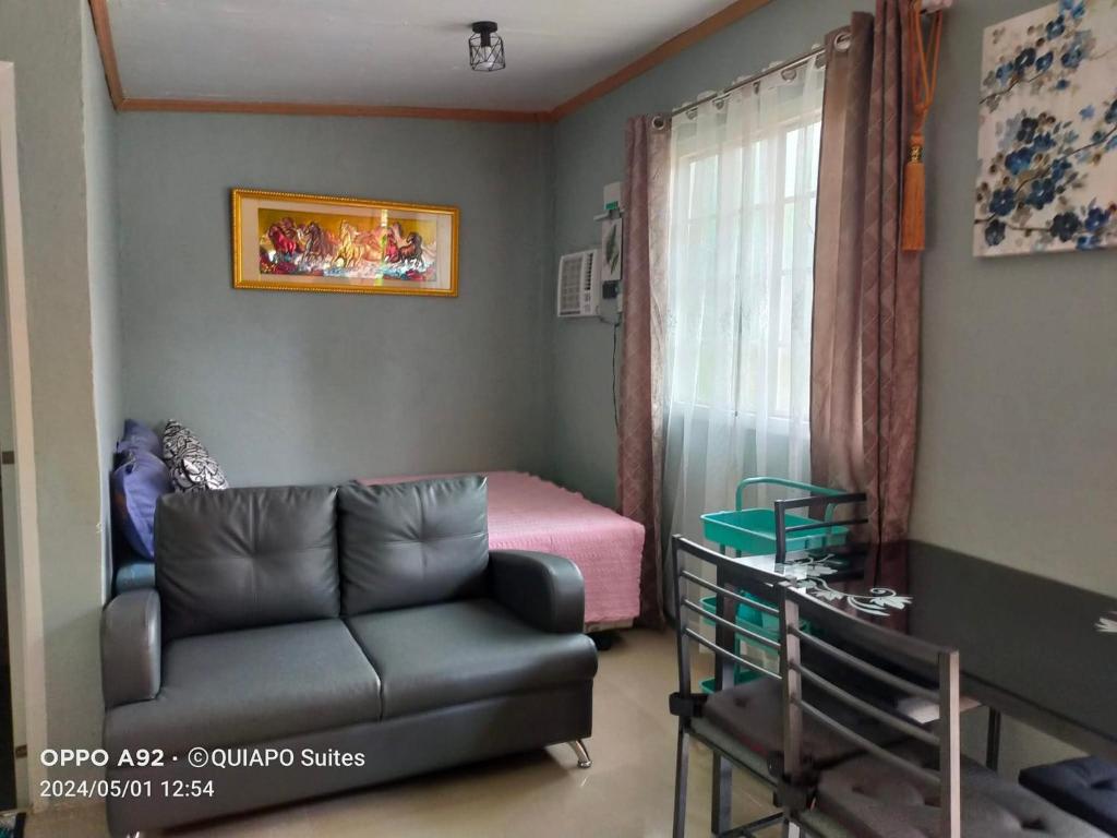 a living room with a couch and a bed at Bohol Stays in Tagbilaran City