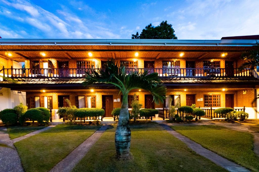 a building with a palm tree in front of it at coucou br hotel in Pooc