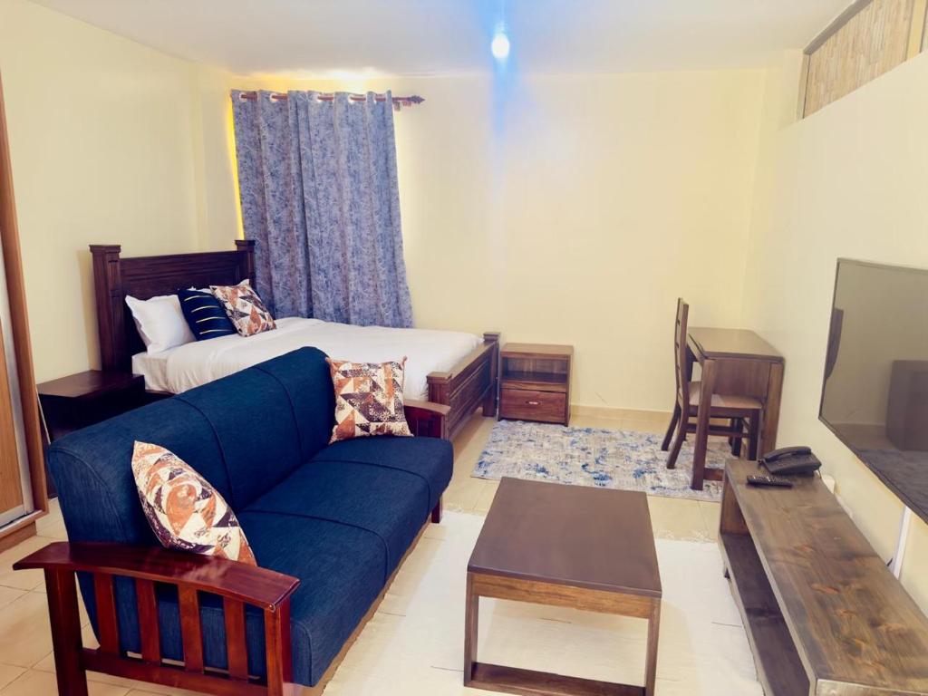 a living room with a couch and a bed at Chic Studio Apartment near Nairobi CBD in Nairobi