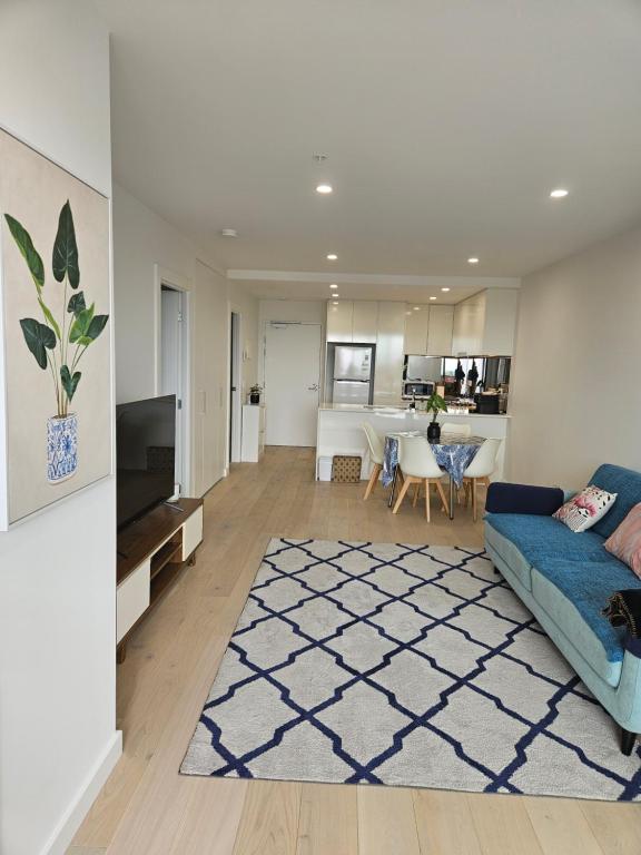 a living room with a couch and a table at Glen Oasis - Luxury Apartment in Glen Waverley