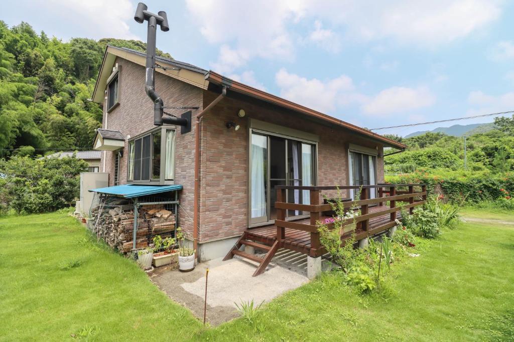 a brick house with a porch and a bench at 南伊豆ガーデンヴィラ in Minamiizu