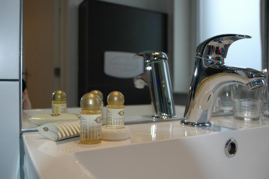 a bathroom sink with a faucet and a mirror at Lavan in Leuven