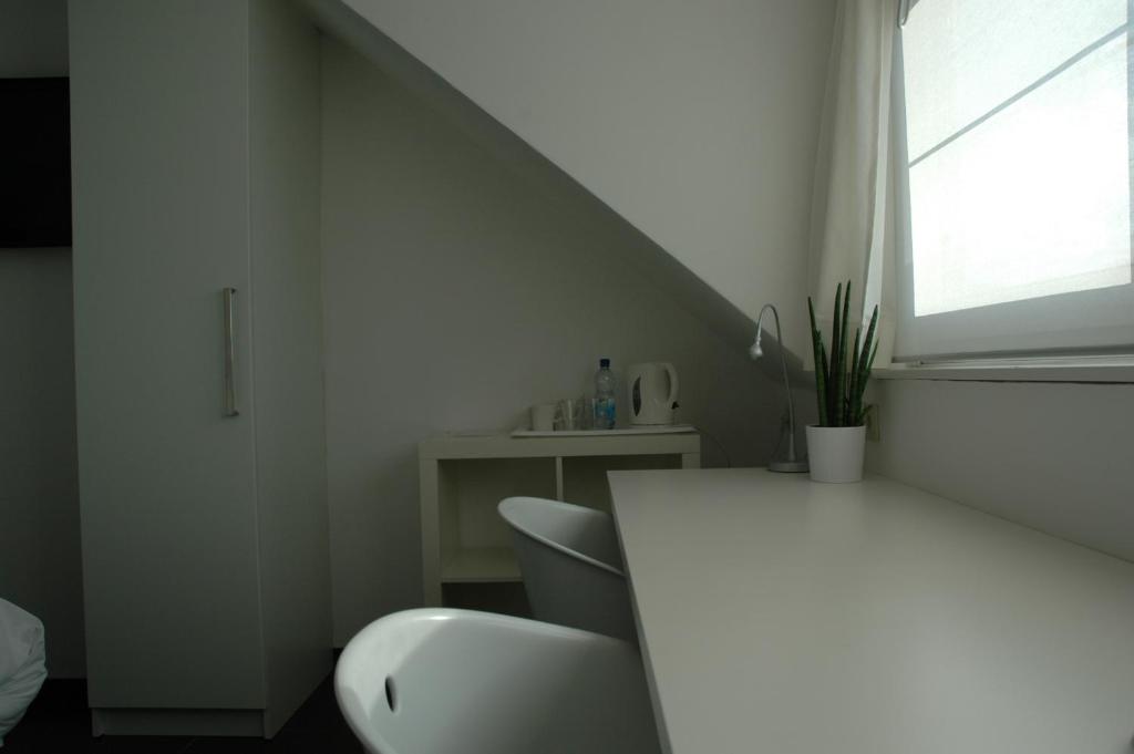a white room with a table and chairs and a window at Lavan in Leuven