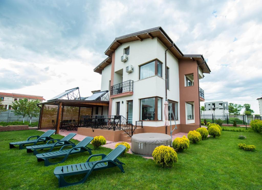 a house with a bunch of chairs in the yard at Elina in Techirghiol