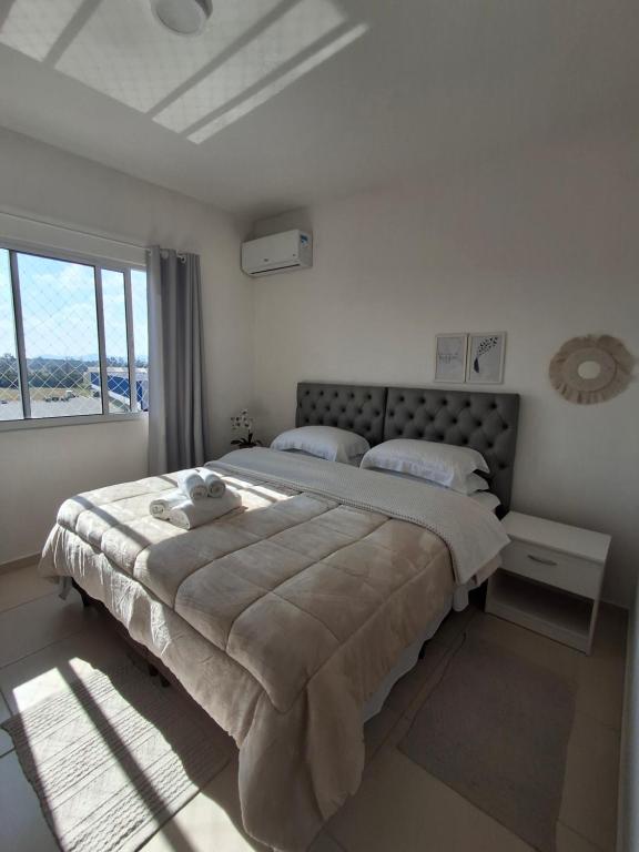 Un dormitorio con una cama grande con una ventana grande. en Apartamento para locação em Itajai SC, en Itajaí
