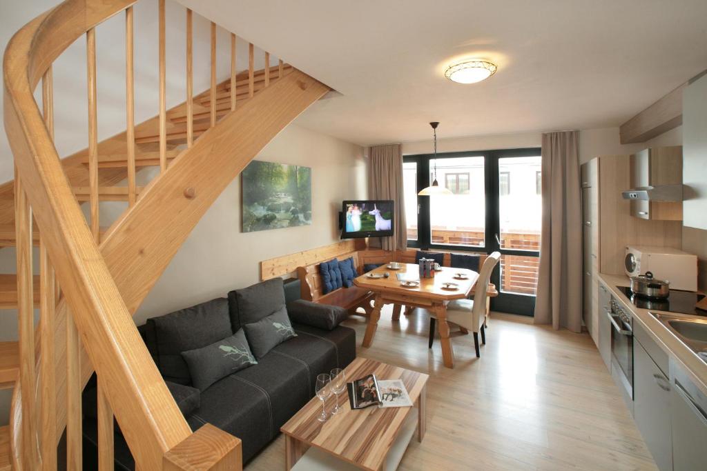 a living room with a couch and a staircase at der Wildbachhof - Contactless check in in Zell am See