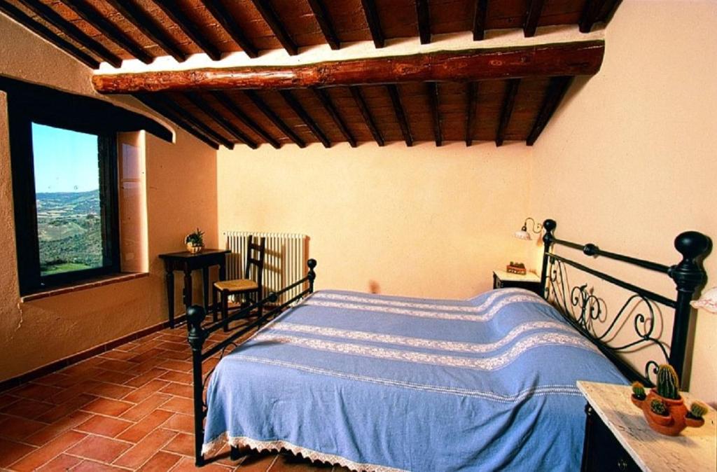 a bedroom with a bed with a blue comforter at Le Piane in Castiglione dʼOrcia