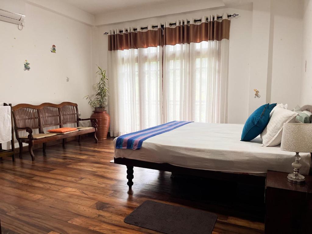 a bedroom with a large bed and a wooden floor at Kandy Breeze Homestay in Kandy