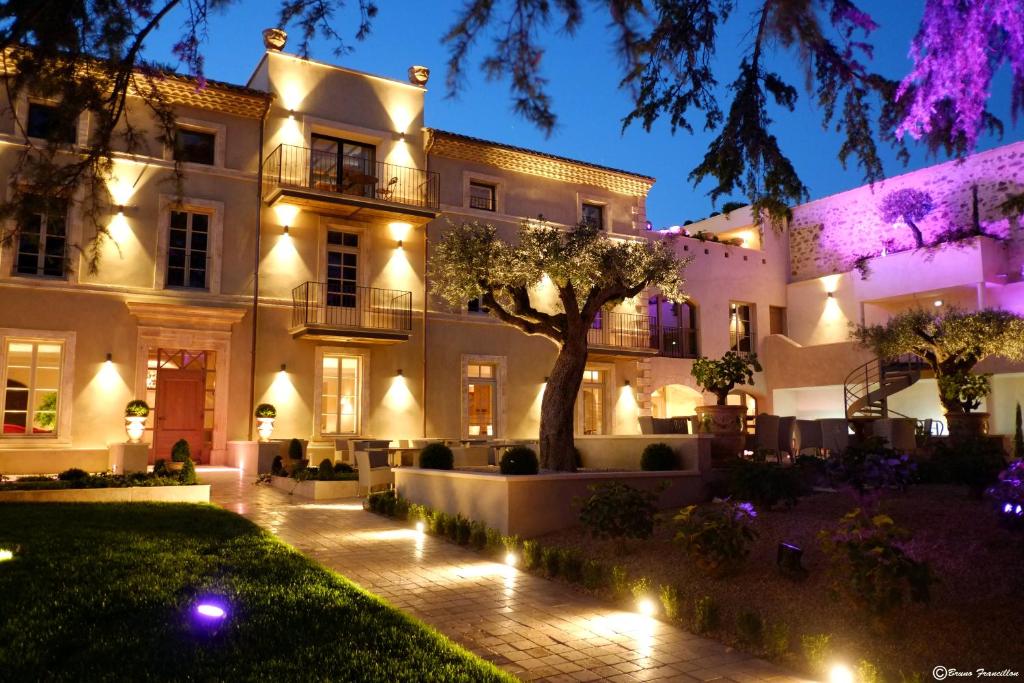 una casa con luces delante de ella por la noche en Boutique Hôtel La Villa MONTESQUIEU en Laudun