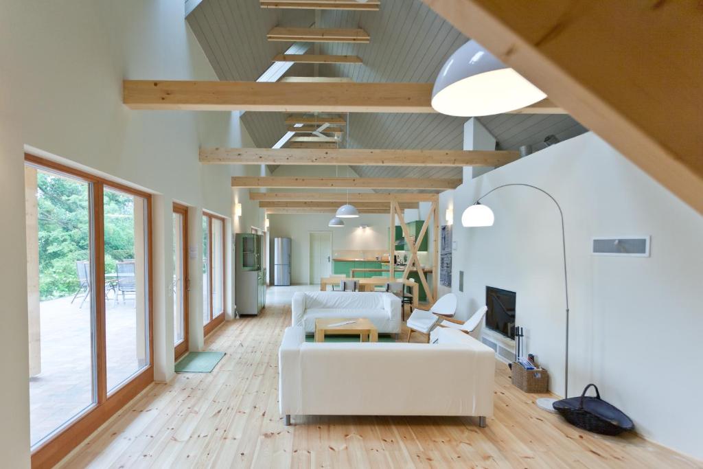 Irota EcoLodge في Irota: غرفة معيشة بأثاث أبيض ونوافذ كبيرة