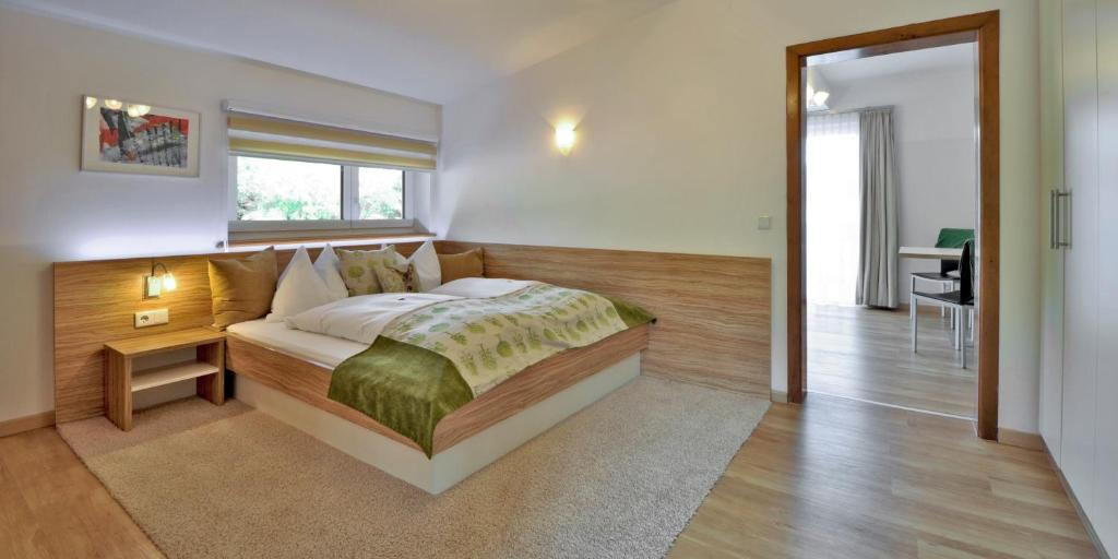 a bedroom with a bed and a table and a desk at Hotel Garni Wurzer in Velden am Wörthersee