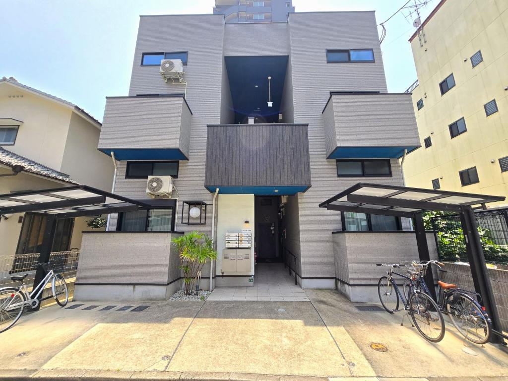 ein Gebäude mit zwei Fahrrädern, die davor geparkt sind in der Unterkunft Comfort CUBE PHOENIX Yakuin in Susakiuramachi