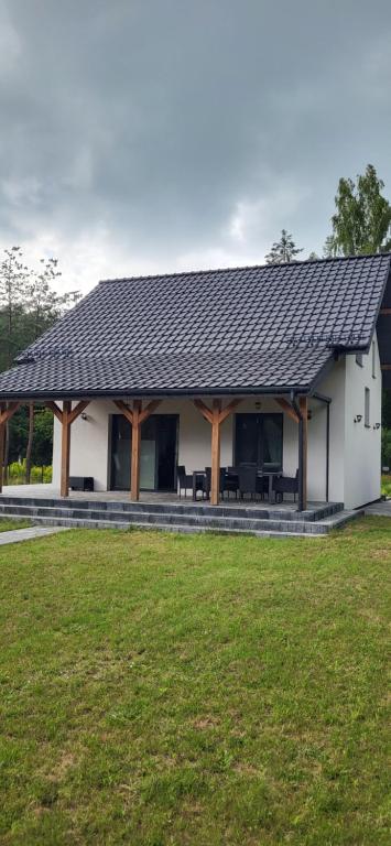 a white house with a black roof at Mazury Lake House Jerutki in Jerutki