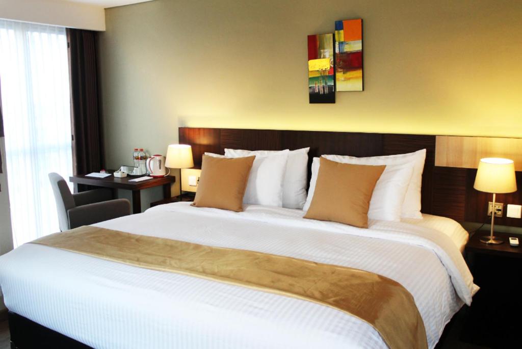 Postel nebo postele na pokoji v ubytování Hotel Gunawangsa MERR