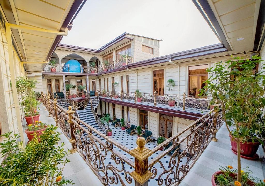 een afbeelding van een herenhuis met een trap en planten bij Hotel Grand House Real Estate in Bukhara