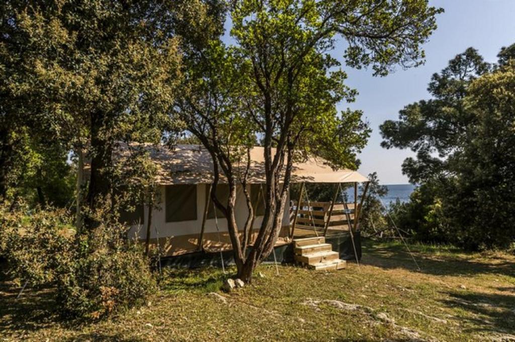 una casa con cenador en un campo con árboles en Easyatent FKK Safari tent Koversada Naturist - clothes free en Vrsar