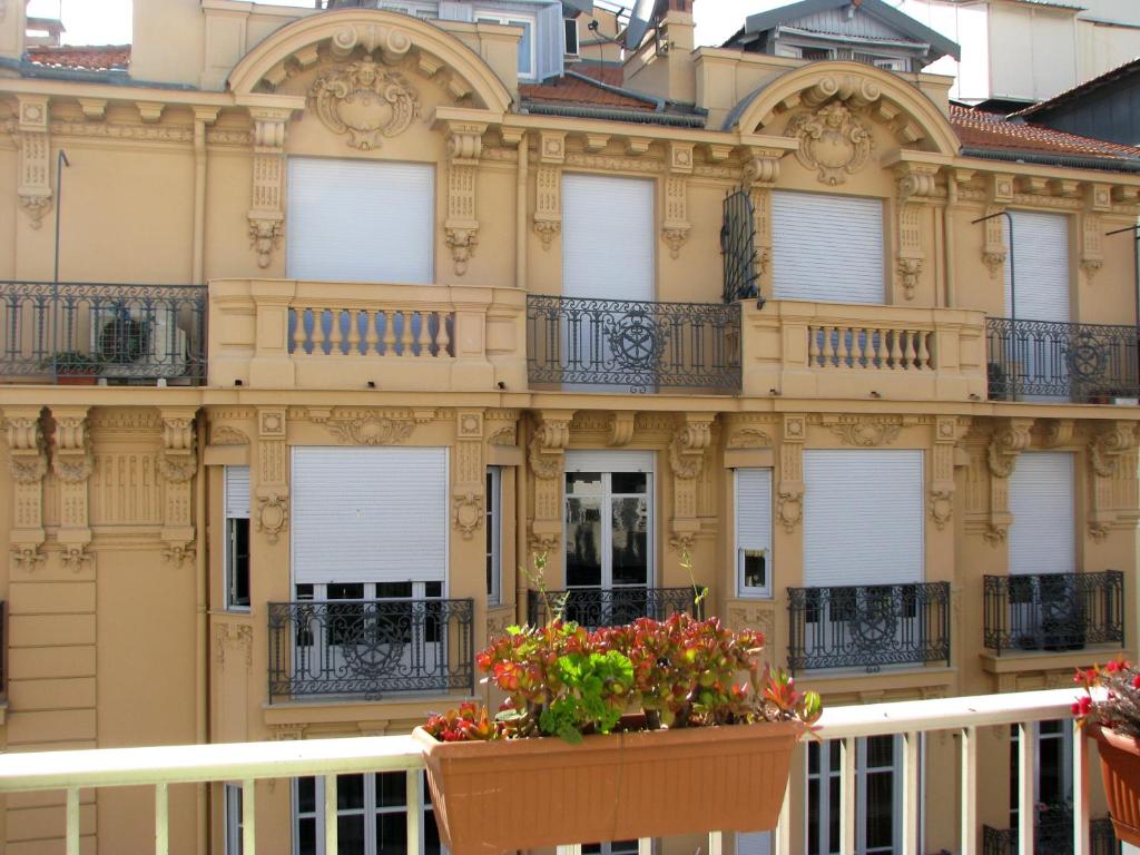 un bâtiment avec des fleurs devant lui dans l'établissement Appartamento Sole, à Nice