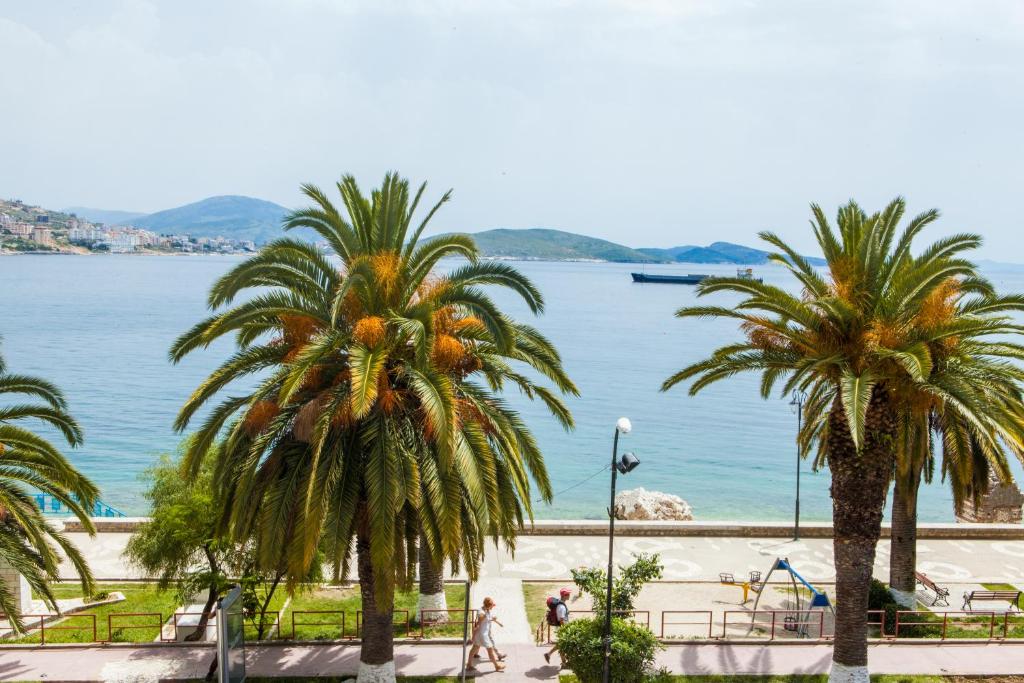 a view of a beach with palm trees at Hotel Pini in Sarandë