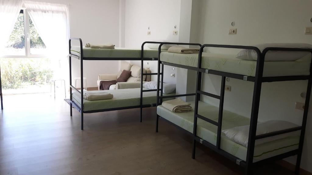 A bed or beds in a room at Albergue O Trisquel