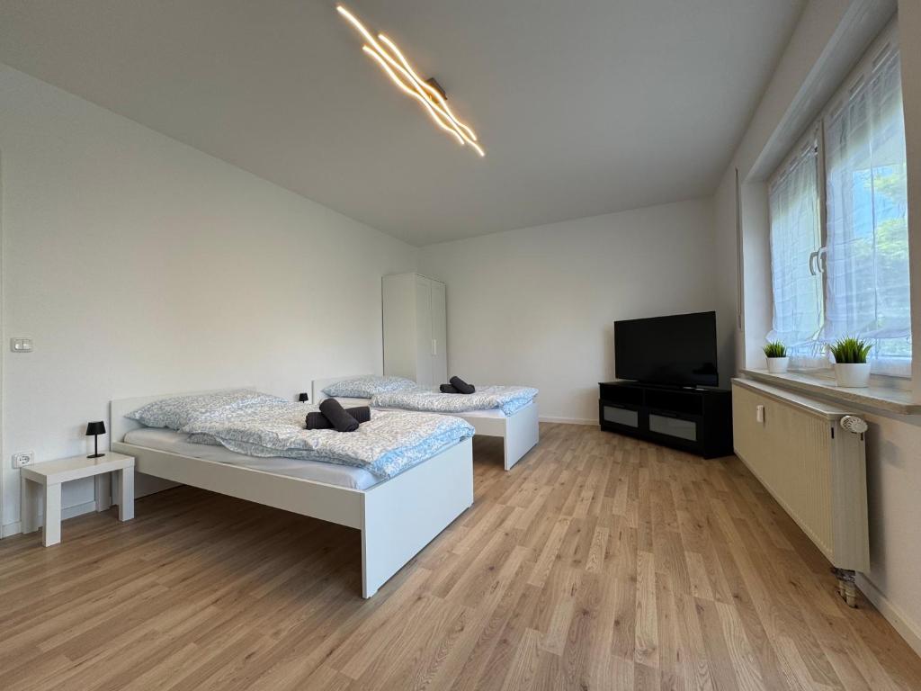 BiberbachにあるWundP Living Wohnung mit Terrasse Parkplatzのベッド2台と薄型テレビ付きのベッドルーム