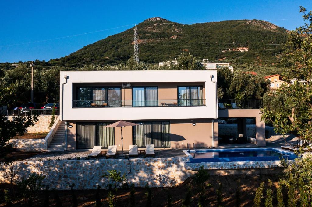 a house with a mountain in the background at Villa Amara -Luxury Villa with Private Pool & Hot Tub in Bar