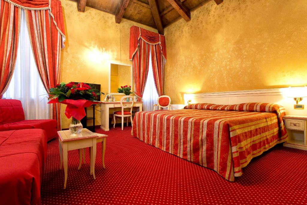 um quarto de hotel com uma cama e um sofá em Ca' San Polo em Veneza