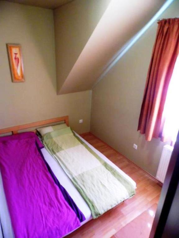 シオーフォクにあるSirály Apartmanの紫のシーツが備わる客室の小さなベッド1台分です。