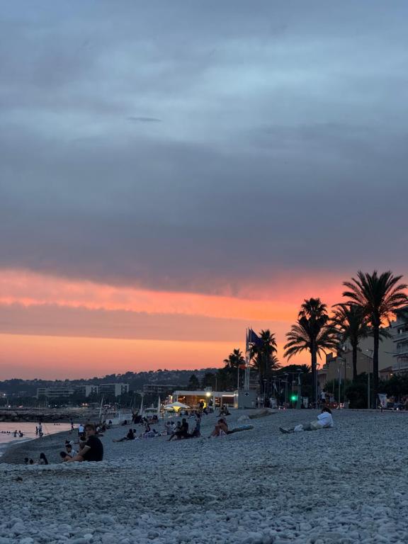 - un groupe de personnes sur une plage au coucher du soleil dans l'établissement F2 cagnes sur mer proche mer et commerces location saisonnière, à Cagnes-sur-Mer