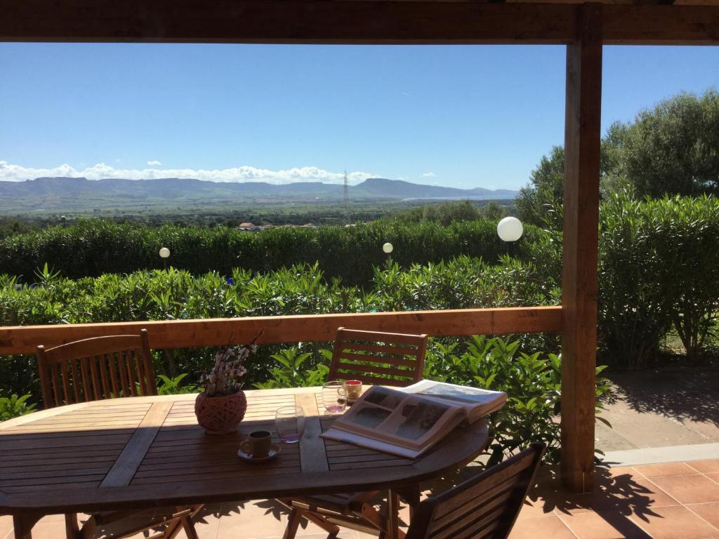 una mesa y sillas en un porche con vistas en A.I.R. Badesi Borgo di Mare, en Badesi