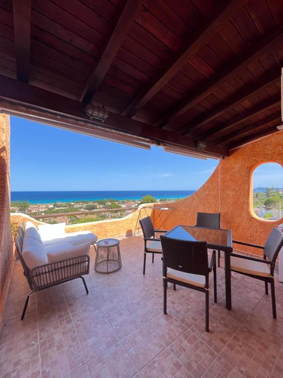 a patio with chairs and a table and a view of the ocean at APPARTAMENTI BIANCANEVE by VILLA AUREA CAV in Costa Rei