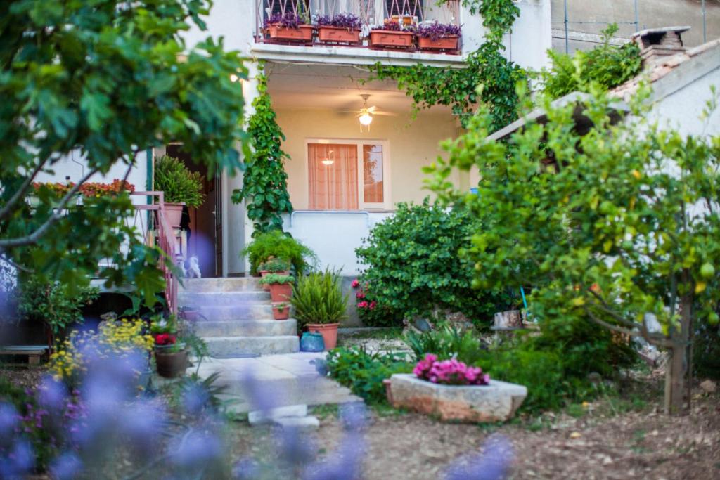 a house with a bunch of plants in the yard at Garden Apartments in Komiža