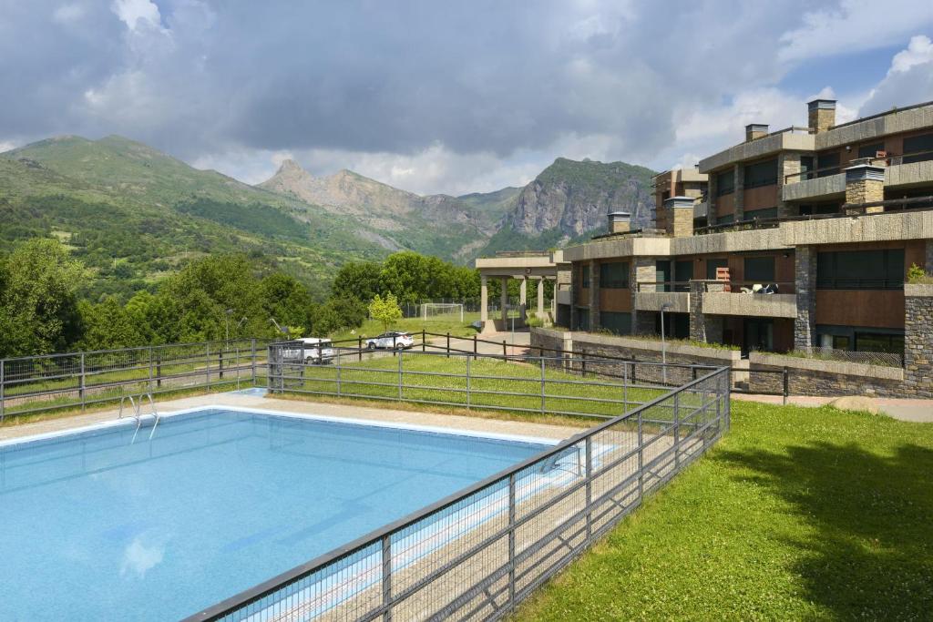 an outdoor swimming pool with mountains in the background at Apartamento Argualas V - WOWRURAL in Panticosa