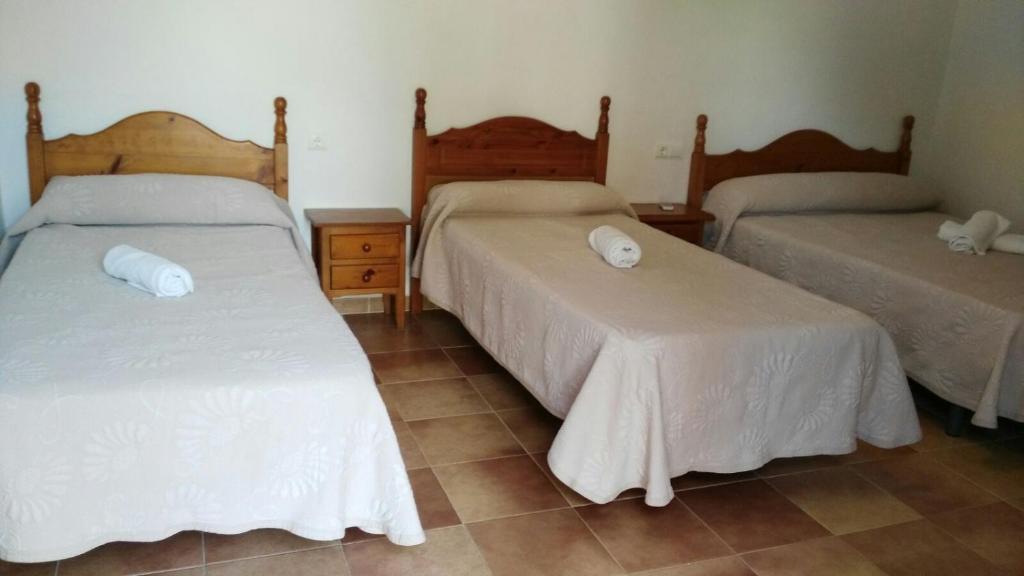 コニル・デ・ラ・フロンテーラにあるHostal las Parcelasのベッドルーム1室(白いシーツが備わるベッド2台付)