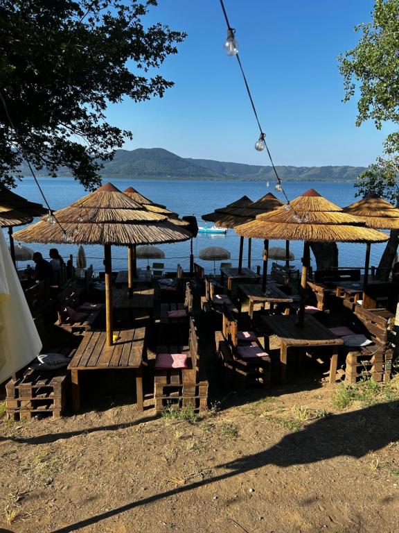 un grupo de mesas y sombrillas en una playa en Casa Etrulia, en Fabrica di Roma