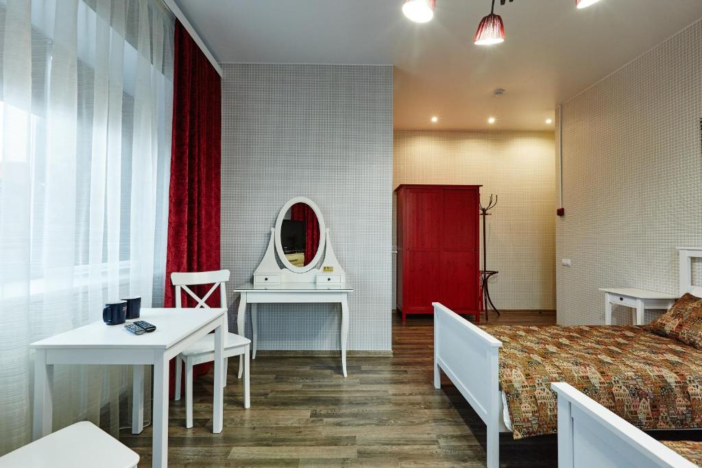 ロデイノイェ・ポリェにあるGuest House Provintsiyaのベッドと鏡が備わるホテルルーム