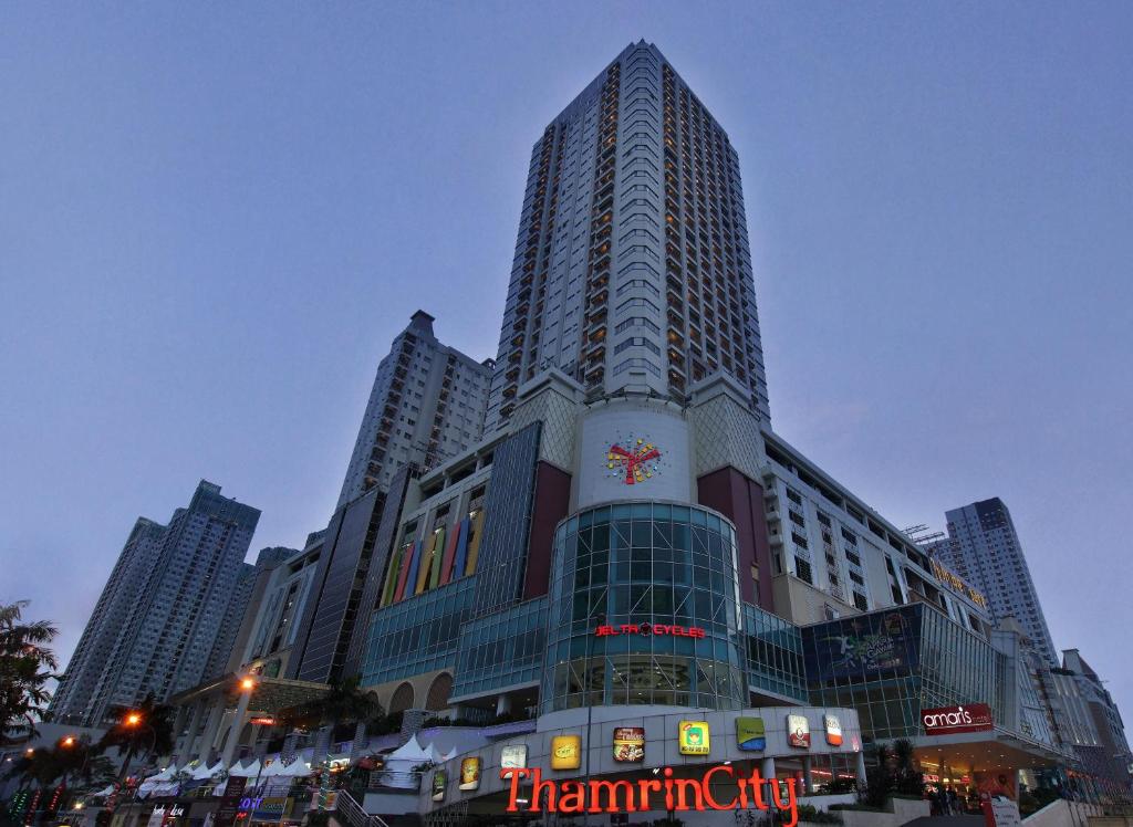 a tall building with a clock on the side of it at Amaris Hotel Thamrin City in Jakarta