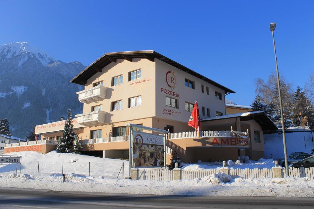 un gran edificio con nieve delante en Gasthof Ambachhof, en Oetz