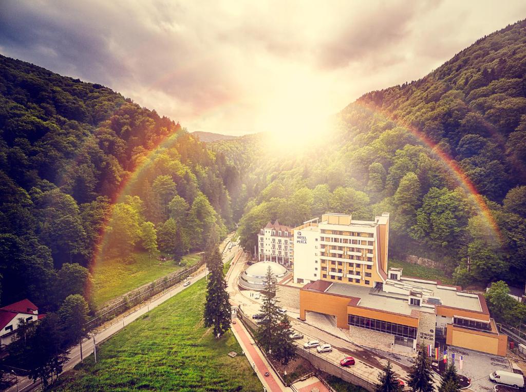 a view of a building with a rainbow in the background at Hotel Perla in Slănic-Moldova
