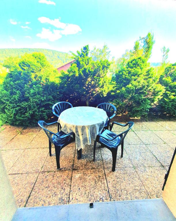 une table et deux chaises assises sur une terrasse dans l'établissement Appartement chalet avec chambre et terrasse, à Gérardmer