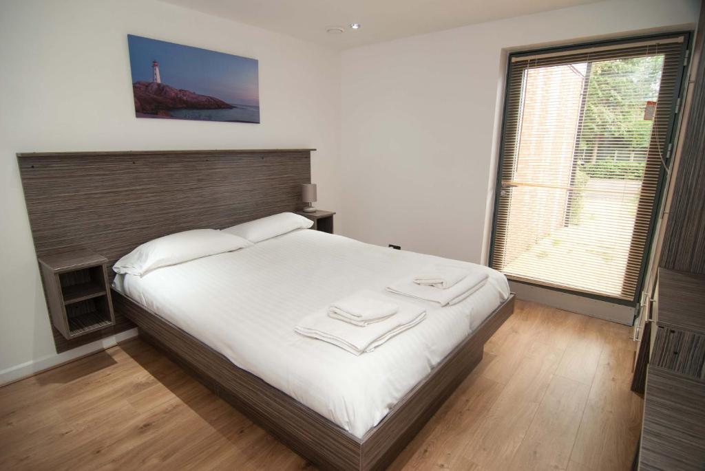 a bedroom with a large bed and a large window at Southampton Serviced Apartments in Southampton